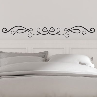 Adesivi per testata letto da muro applicati su parete bianca con decoro calligrafico e cuori, ideali per camera da letto elegante.