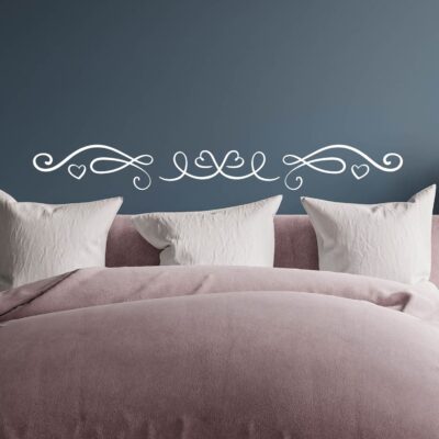 Decorazione murale con adesivi per testata letto da muro su fondo colorato, con design simmetrico e motivi a cuore.