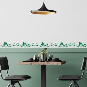 Greche decorative adesivi per cucina con motivo a foglie di vite verdi applicate su parete bianca in una sala da pranzo moderna.