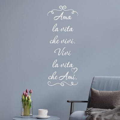 Adesivo murale frase motivazionale bianco su parete grigia in angolo relax con poltrona grigia e tavolino con tulipani.