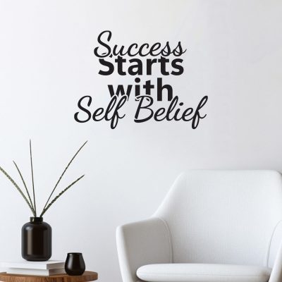 Scritte da muro adesive motivazionali "Success Starts with Self Belief" su parete bianca in soggiorno arredato in stile moderno.